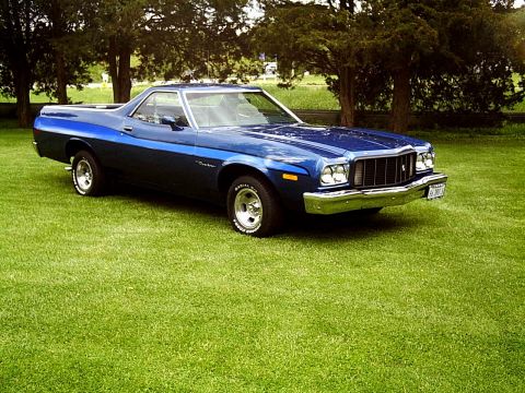 1973 Ford Ranchero - A blue 1977 Ford Ranchero with racing stripes sits on a green lawn under trees.