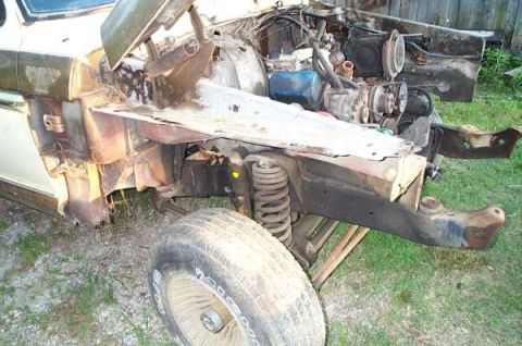 1979 Ford Bronco - The front end of a 1978 Ford Bronco is shown with the hood removed, revealing the engine and suspension components.