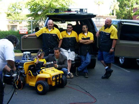2000 Ford Excursion - A film crew and participants gather around a toy car and an SUV, with a 'NEWS ONLY' sign visible.