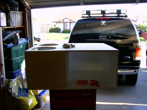 2000 Ford Excursion - A custom speaker box sits in front of a black Ford Excursion parked in a garage.