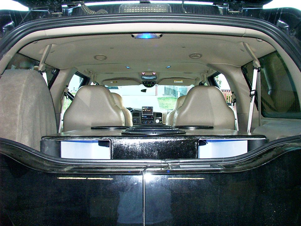 Rear cargo view of SUV interior with custom box, drawers, and tan leather seats