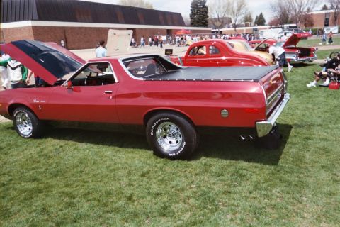 1972 Ford Ranchero - A red 1972 Ford Ranchero is displayed with its hood open at a car show, alongside other vehicles.