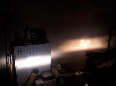 1989 Ford Bronco II - Headlights illuminate a wall in a garage, casting light on a cabinet and various items.