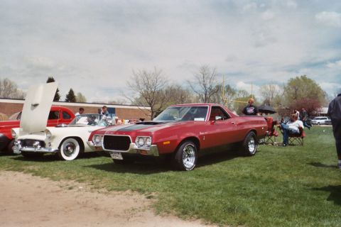 1972 Ford Ranchero - A red 1972 Ford Ranchero is displayed at an outdoor event with other vehicles and spectators.