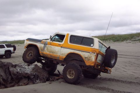 1996 Ford Bronco - This lifted 1978 Ford Bronco navigates a sandy terrain, with another SUV visible in the background.
