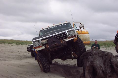 1996 Ford Bronco - Modified Ford Bronco with "BIG BRONCOS 4X4 CLUB" sticker on windshield, driving on sand.