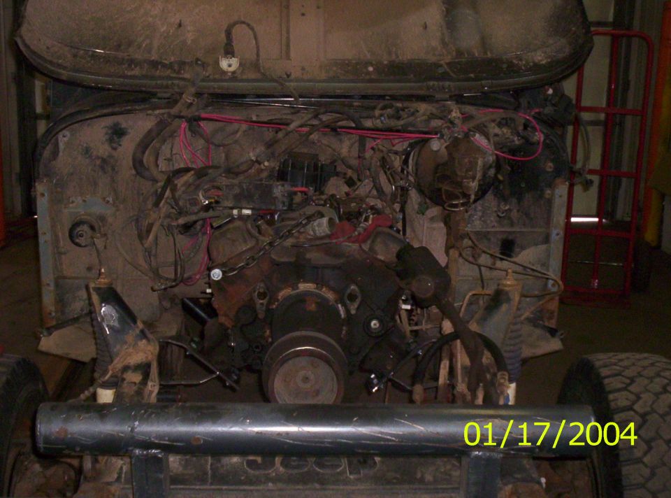 Front of Jeep Wrangler with grille removed showing engine and wiring, black tube bumper, dated 01/17/2004