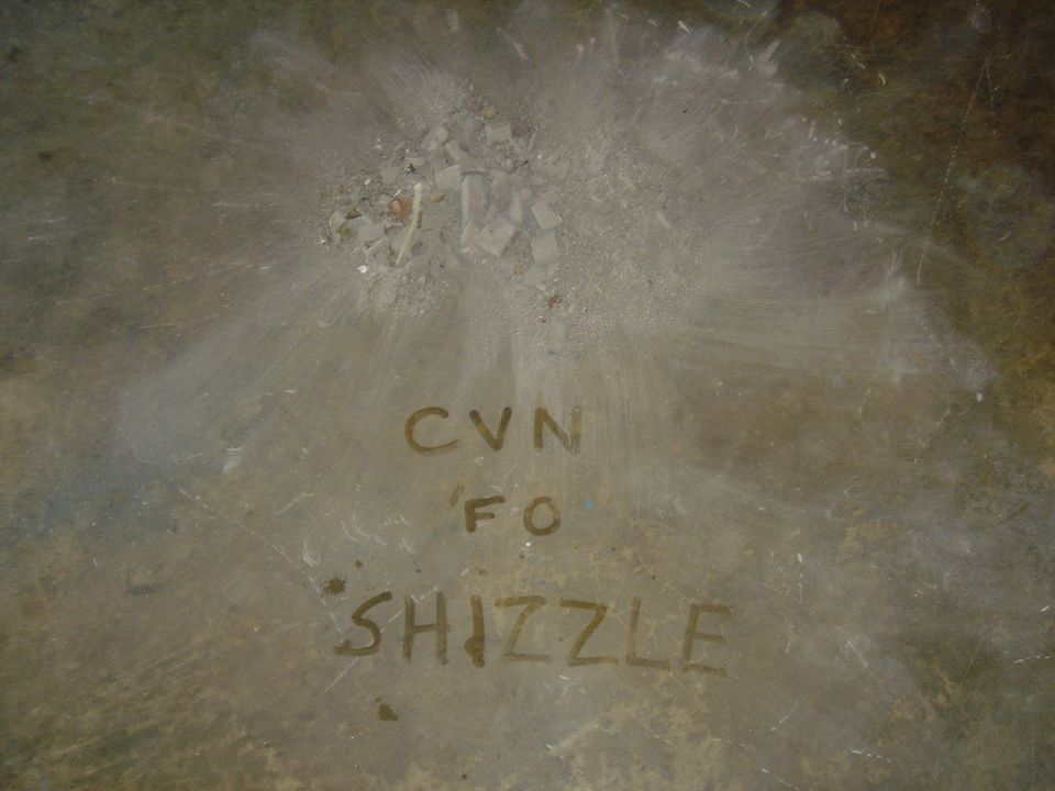 Metal surface with handwritten text CVN FO SHIZZLE and a Supermotors.net logo