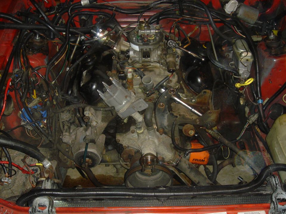 Engine bay with carburetor and distributor, red car interior