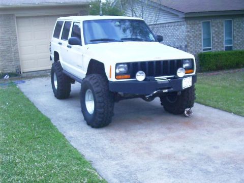 1986 Ford Bronco - This lifted Jeep Cherokee XJ features oversized tires and a custom bumper, giving it an aggressive off-road stance.