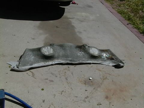 1999 Ford Taurus - A car's underbody shield is shown on a concrete surface, possibly after removal for maintenance.