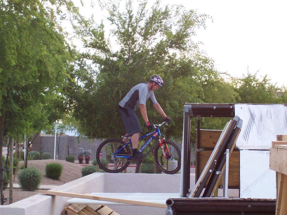 Guy on a bike riding on a ledge near a ramp