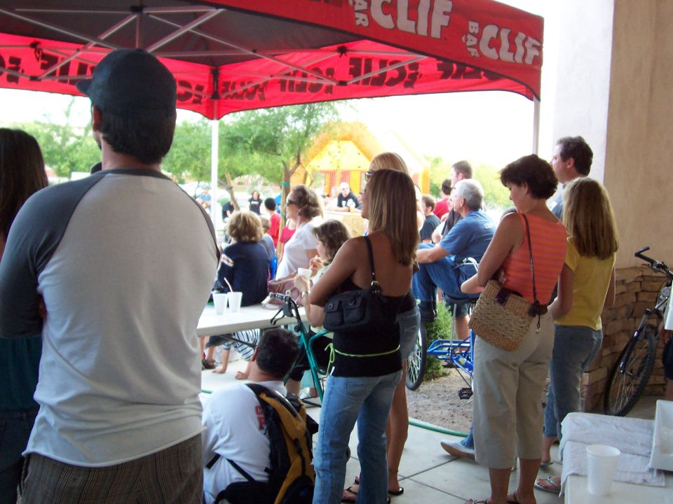 People gathered under a red Clif Bar tent, with a bicycle on the right