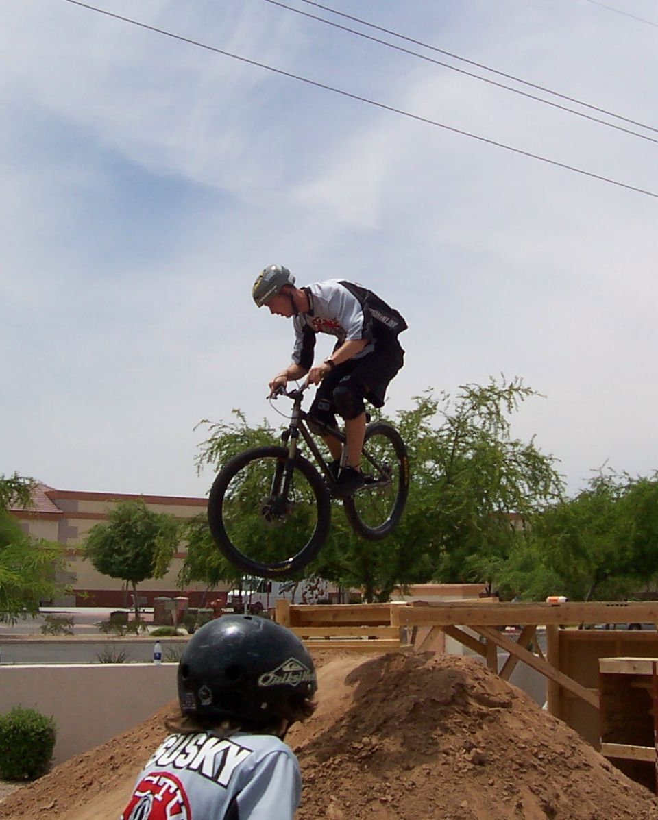 Mountain biker performing a jump on a dirt track