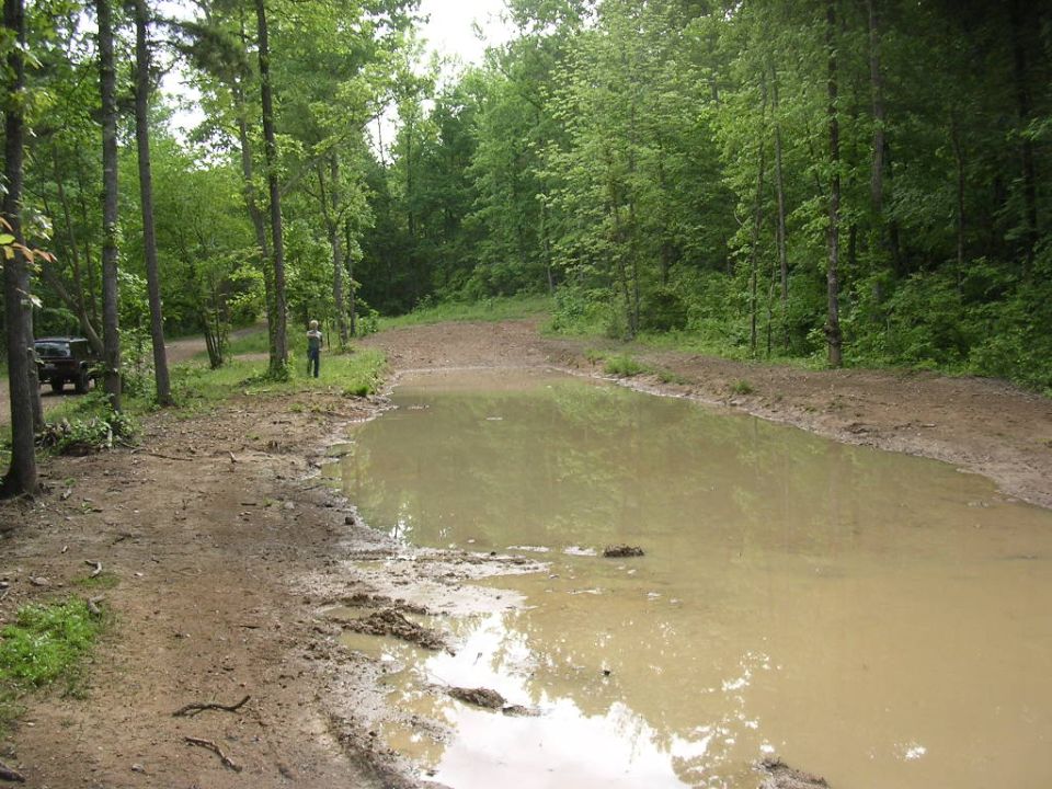 1995 Jeep Cherokee parked on muddy trail near puddle