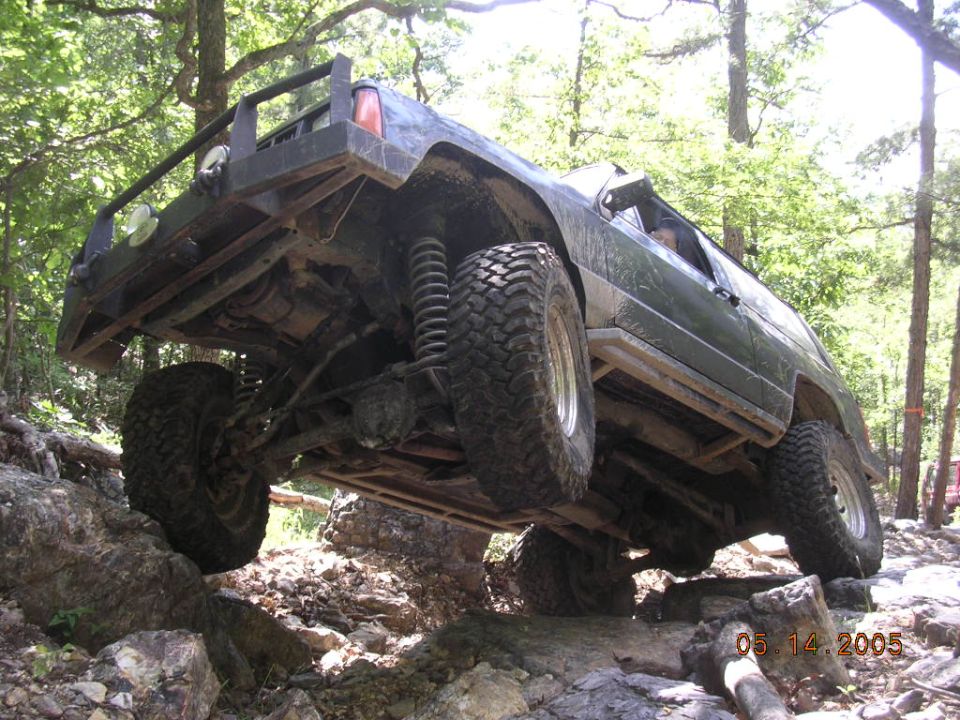 Modified 1995 Jeep Cherokee climbing rocks on an off-road trail