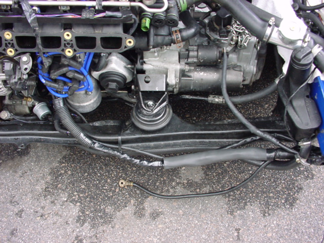 Engine bay with blue spark plug wires and black hoses