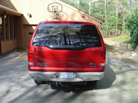 2002 Ford Excursion - Rear view of a red 2002 Ford Excursion Limited SUV parked in front of a house.