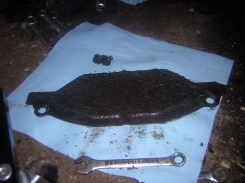 1995 Ford Bronco - Transmission pan drain plug and bolts, likely needing cleaning or replacement.