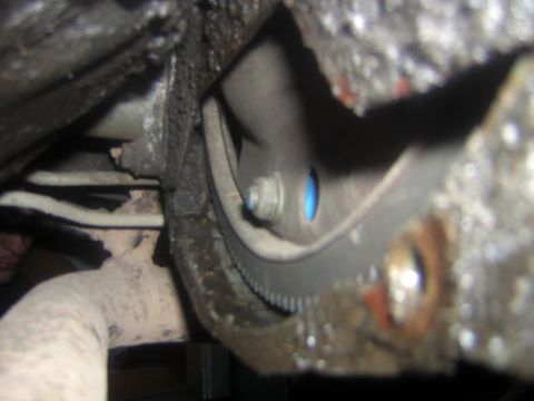 1995 Ford Bronco - Underside view of a vehicle's transmission bell housing, showing mechanical components.