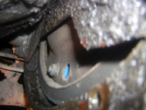 1995 Ford Bronco - Close-up view of a transmission bell housing and flexplate, showing mechanical components.