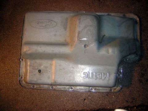 1995 Ford Bronco - A metal transmission oil pan, marked with a Ford logo and 'Metric' text, is shown from a top-down perspective.