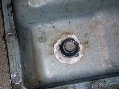 1995 Ford Bronco - Close-up of a transmission pan drain plug, showing the hex head and surrounding gasket.