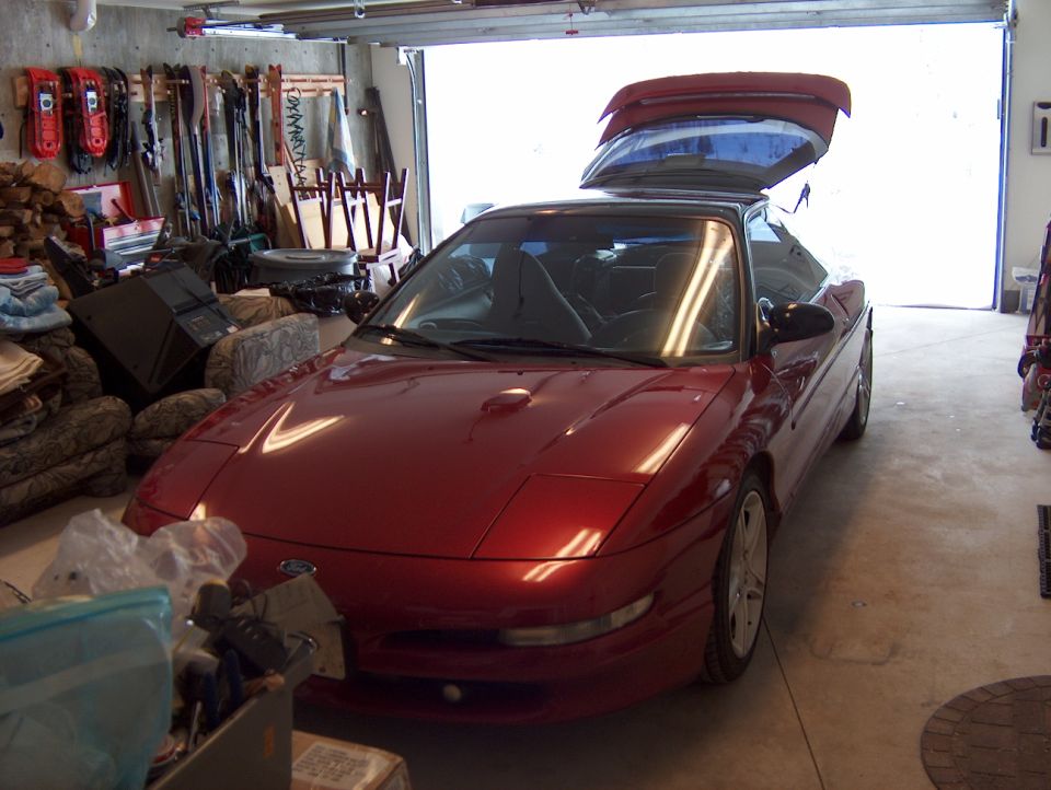 Red 1996 Ford Probe coupe with trunk open in a garage
