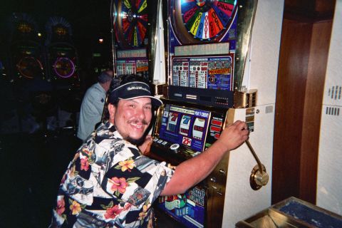 1968 Ford Mustang - Man plays a slot machine in a casino, with other machines visible in the background.