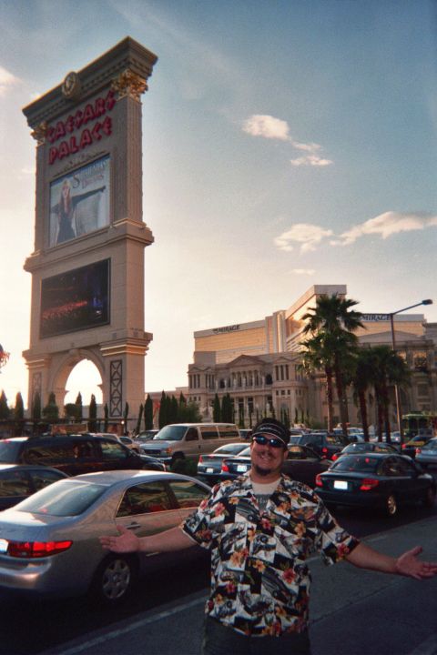 1968 Ford Mustang - A man poses for a photo in front of the Las Vegas Palace sign with a busy parking lot and hotel in the background.