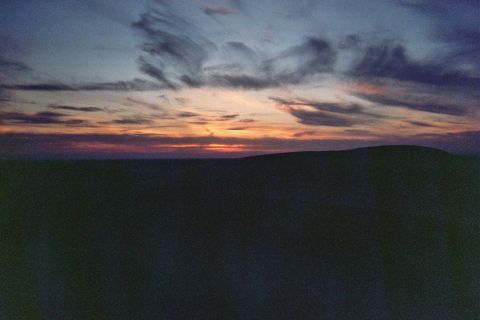 1968 Ford Mustang - A colorful sunset paints the sky over rolling desert dunes, creating a landscape.