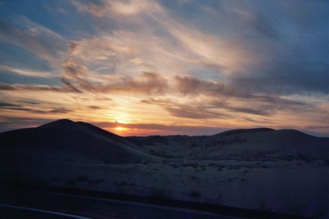 1968 Ford Mustang - Sunset over rolling desert hills with wispy clouds in the sky.