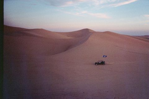 1968 Ford Mustang - A lone dune buggy traverses the vast sand dunes under a twilight sky.