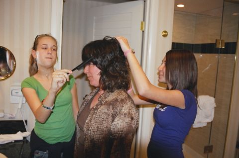 1994 Ford Bronco - Two young women comb the hair of an older woman in a bathroom setting.