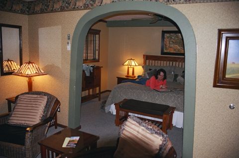 1994 Ford Bronco - A person is on a bed in a hotel room, reading a book. The room has a cozy, rustic feel.