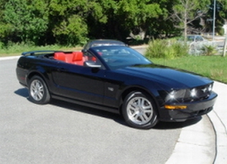 2002 Ford Mustang - This black convertible with a red interior appears to be a 2005 model, not a 2002 as claimed.