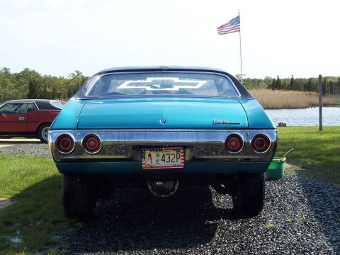 1971 Chevrolet Chevelle - Rear view of a teal 1971 Chevrolet Chevelle parked outdoors with an American flag flying in the background.