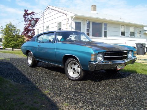 1971 Chevrolet Chevelle - A blue 1971 Chevrolet Chevelle coupe is parked in front of a white house.