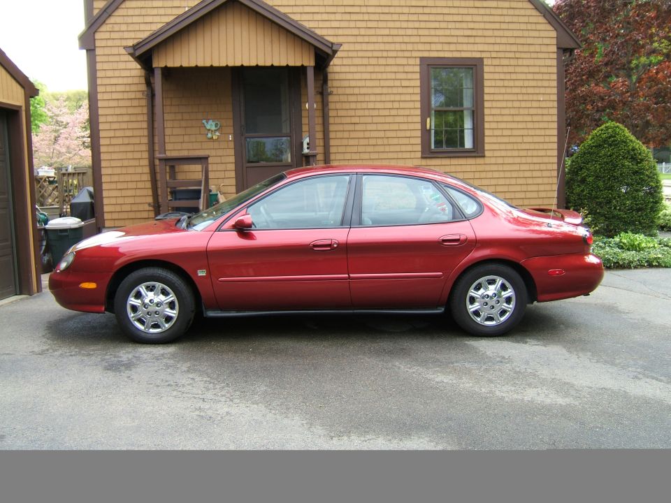 1998 Ford Taurus sedan, side view, parked in front of a house
