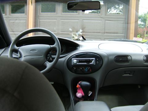 1998 Ford Taurus - The interior of a car is shown, with a view of a garage door through the windshield.