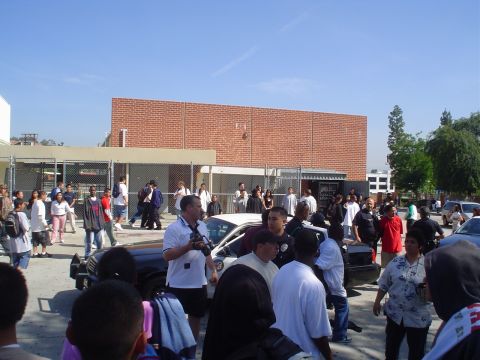 1993 Ford Taurus - A police car is visible amidst a gathering of people in front of a brick building.
