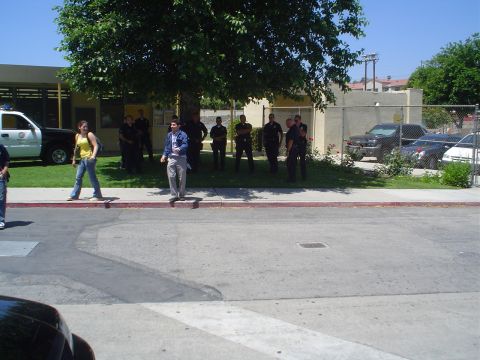 1993 Ford Taurus - A police car is parked on the grass next to a building, with several people standing around it.