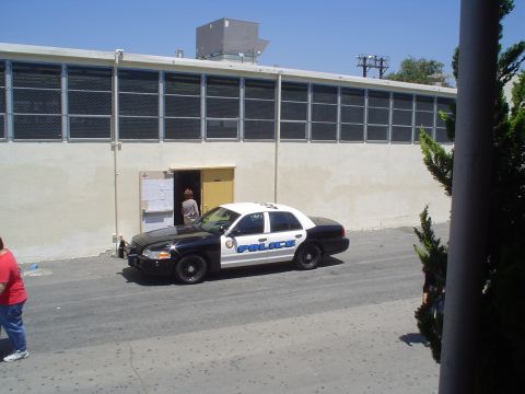 1993 Ford Taurus - A police car is parked in front of a building with a person visible in the doorway.