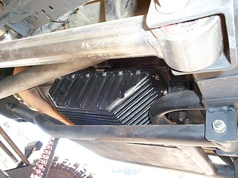 1994 Ford Bronco - Underside view of a vehicle's transmission pan, showing its ribbed design and bolted construction.