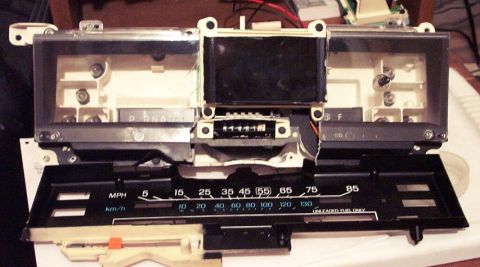 1985 Ford Crown Victoria LTD - This disassembled car instrument cluster shows the speedometer, fuel gauge, and gear indicator.