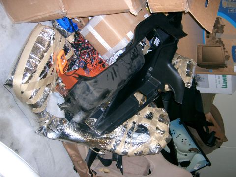 1996 Ford Probe - Various car parts and insulation are piled up with cardboard boxes.