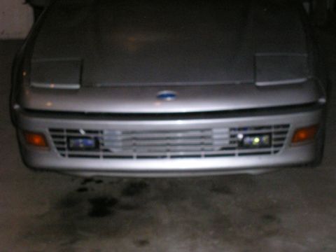 1990 Ford Probe - The front of a silver 1990 Ford Probe is shown, pop-up headlights and a horizontal grille.