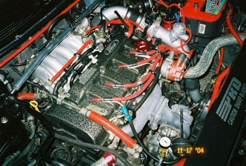 1995 Ford Probe - Modified engine bay with various aftermarket parts and visible text on a component.