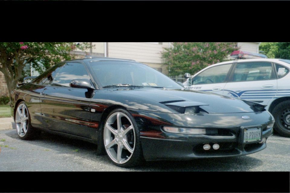 Black 1995 Ford Probe with pop-up headlights and custom wheels