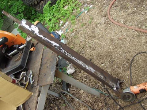 1979 Ford Bronco - A metal beam is shown with welding marks and a threaded end, near tools for fabrication.